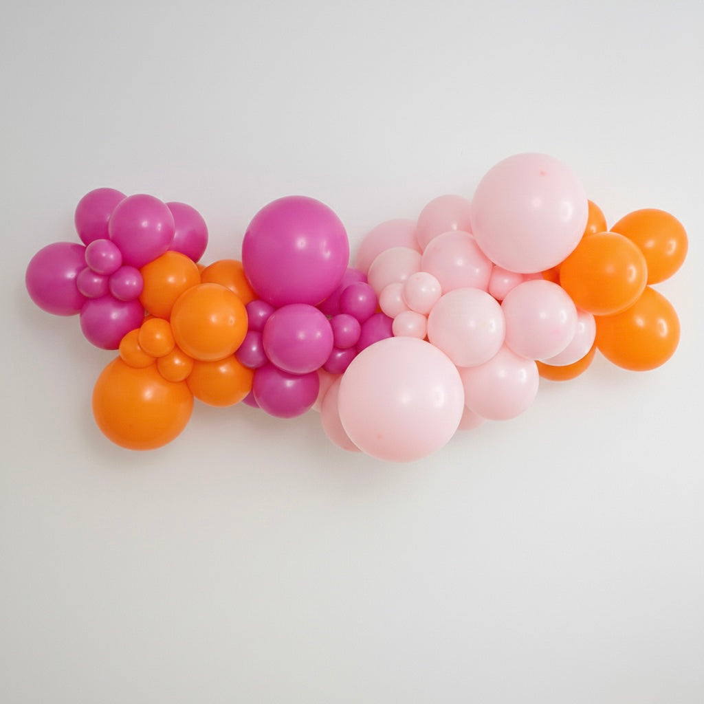 DIY balloon garland in Neon Sherbert colours, featuring Fuchsia Pink, Light Pink and Orange, professional grade, latex balloons. Styled in a professional organic garland.